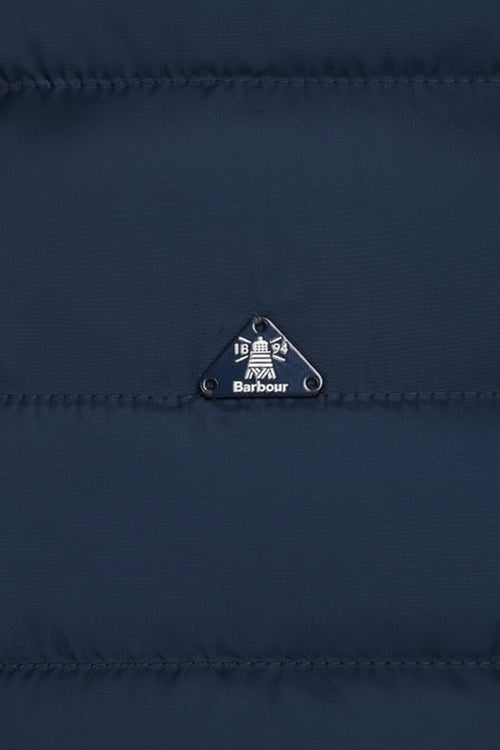 Barbour logo patch on navy quilted jacket with metal eyelet pull tab
