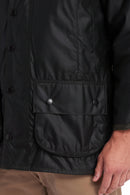 Dark wax jacket with snap buttons, storm flap hem, and side pocket flaps