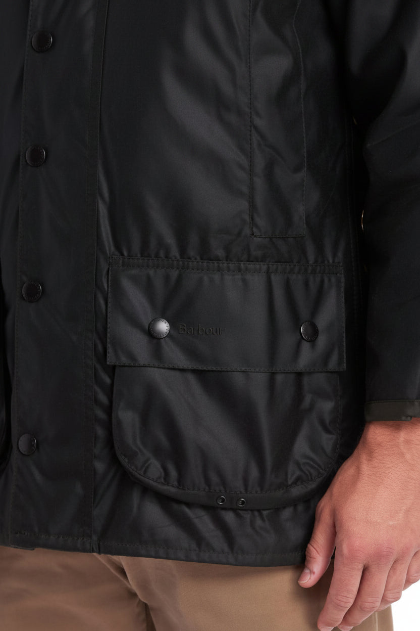 Dark wax jacket with snap buttons, storm flap hem, and side pocket flaps