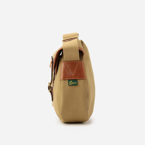 Khaki large crossbody bag with brown leather trim, front pocket, and adjustable strap.