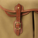 Brown leather strap loop with brass buckle on khaki bag edge