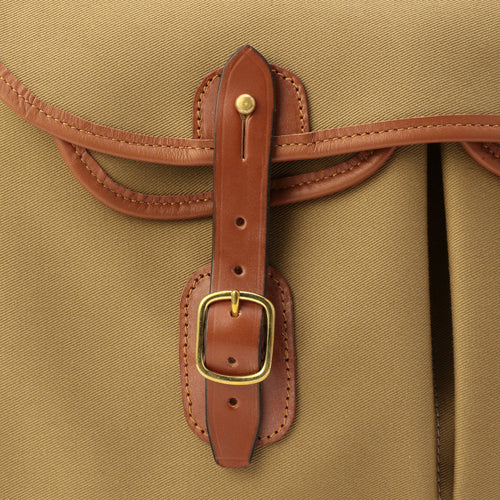Brown leather strap loop with brass buckle on khaki bag edge