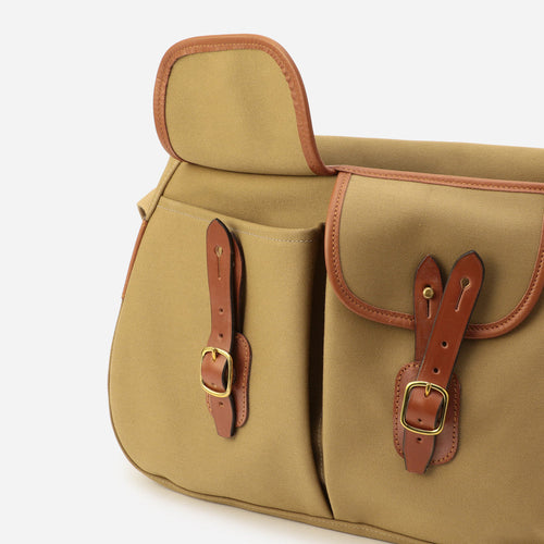 Khaki canvas bag with front flap pockets, brown leather buckles, and center seam
