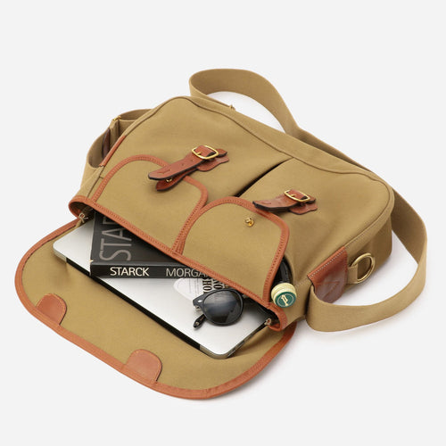 Khaki canvas bag with open top showing lined interior and small accessories