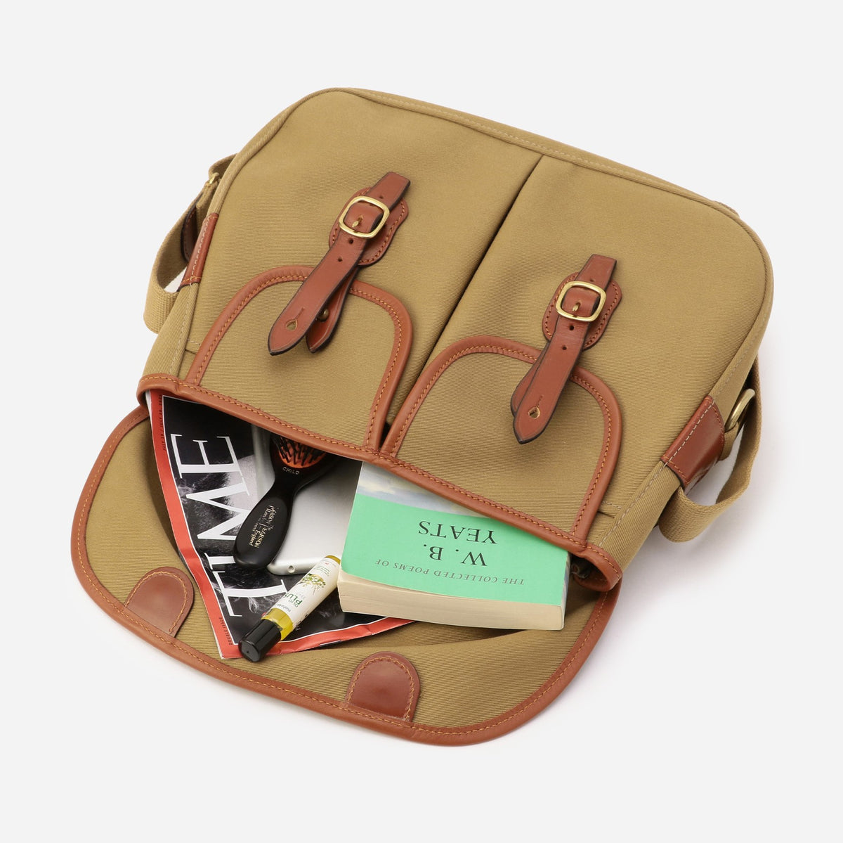 Small khaki crossbody bag shown open with interior pockets and brown leather trim