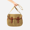 Khaki small crossbody bag held by its strap with brown leather buckle accents