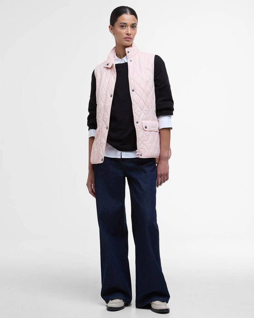 Barbour women's quilted pink gilet worn over dark sleeves with button front
