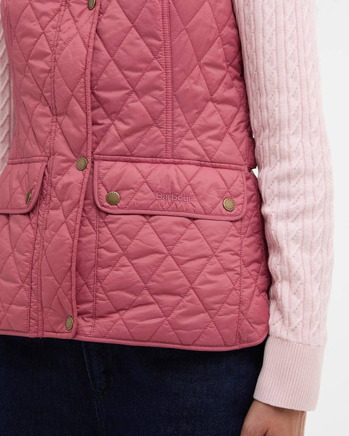 Wildberry pink quilted gilet detail: side button-flap pocket with green snaps