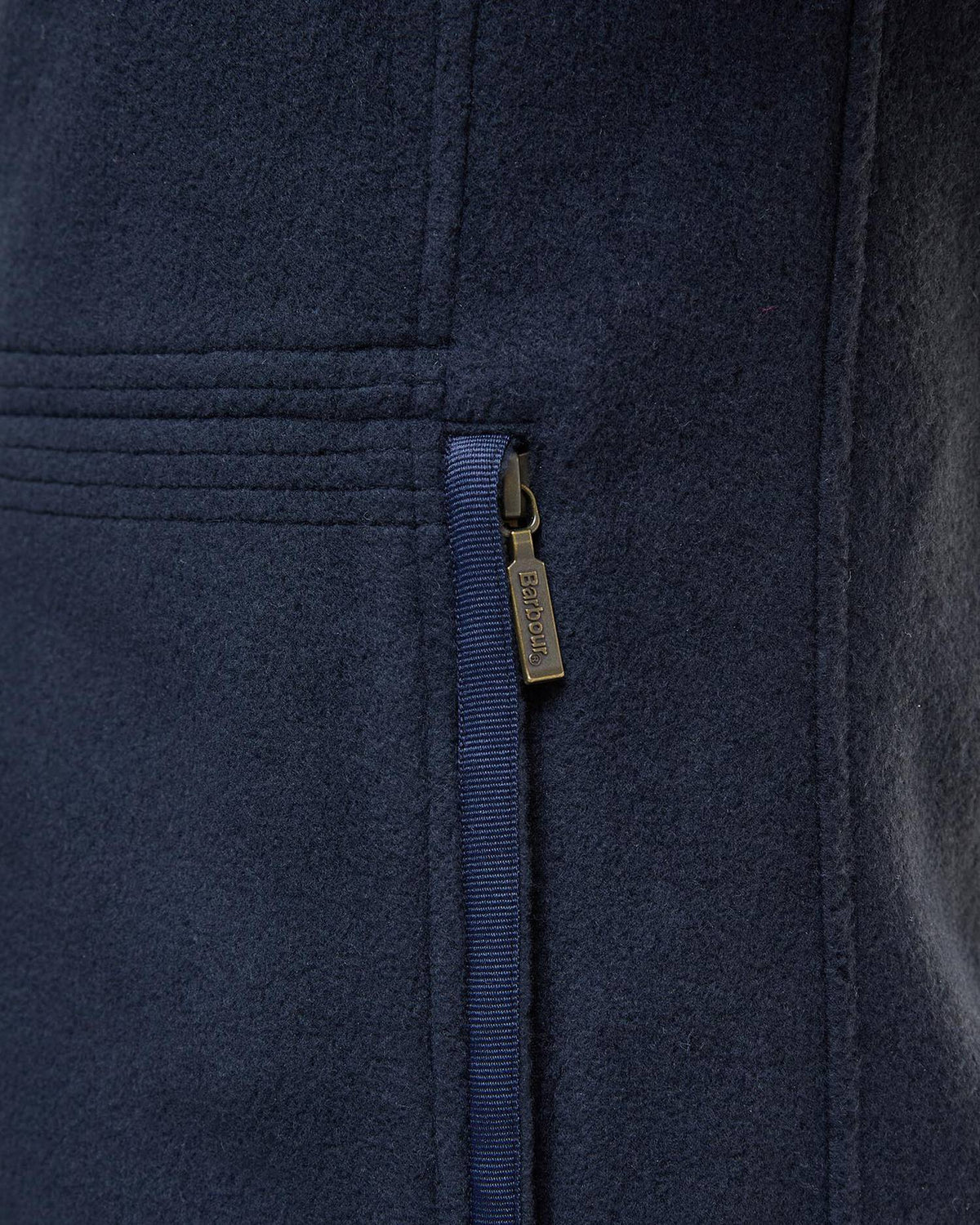 Navy fleece waistcoat close-up of full-zip track and logo tag on front panel