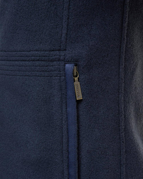 Navy fleece waistcoat close-up of full-zip track and logo tag on front panel