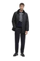 Barbour men's black quilted jacket worn over a crewneck and trousers