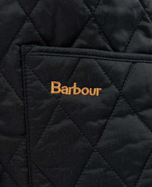 Barbour logo on black quilted jacket pocket, close-up