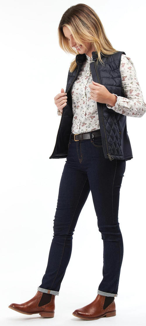 Navy quilted Barbour gilet with gold zip and snap pockets over jeans