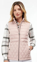 Pastel pink quilted gilet with full zip and diamond quilting, worn with plaid sleeves