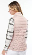 Pastel pink quilted gilet with high neck and horizontal padding, worn over plaid shirt