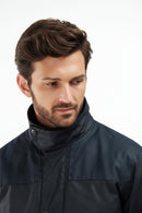Men's navy wax jacket with snap front, stand collar, and flap chest pockets