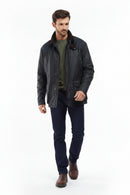 Men's navy wax jacket worn with jeans and brown boots, front view