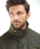 Olive wax jacket stand collar with brass snap button and front yoke