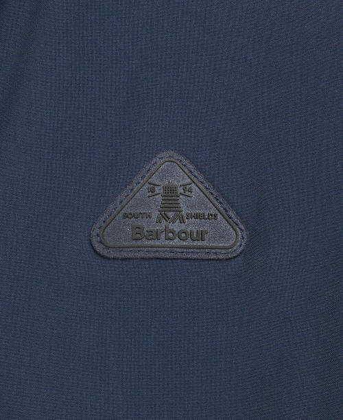 Barbour logo patch on navy waterproof jacket, triangular embroidered badge