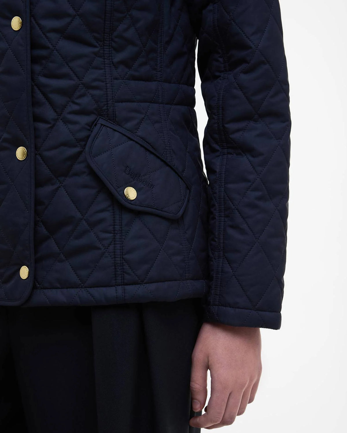 Navy quilted jacket with sleeve seam and side flap pocket closed by a gold button
