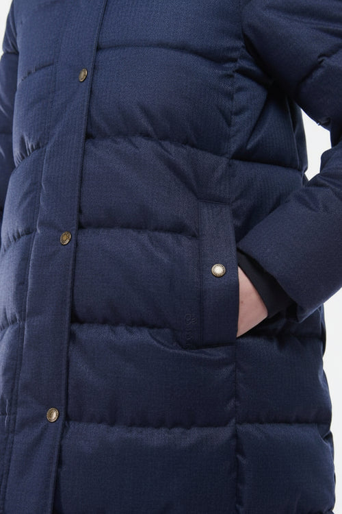 Navy quilted jacket front with gold-tone snaps and padded horizontal baffles