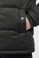 Dark quilted jacket cuff with metal snap and stitched panel detail.