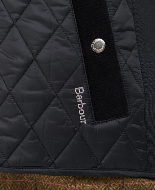 Black Barbour quilted gilet fabric detail with diamond quilting and logo patch