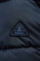 Barbour logo patch on dark navy quilted jacket, triangle emblem on chest