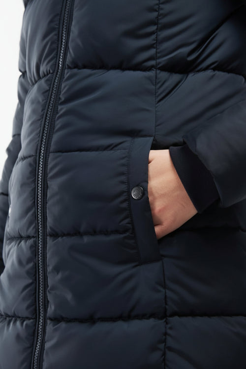 Barbour quilt jacket detail: dark navy puffer panels, front zip, buttoned pocket flap