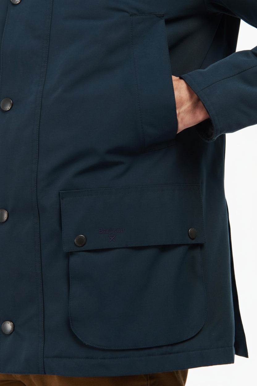Barbour navy parka front view with snap buttons, flap chest pocket, and side pockets