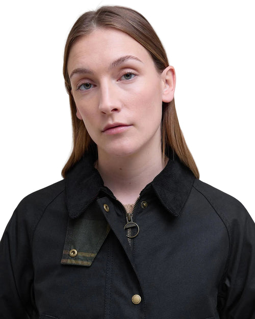 Black women’s wax jacket close-up with stand collar and gold-tone snap buttons