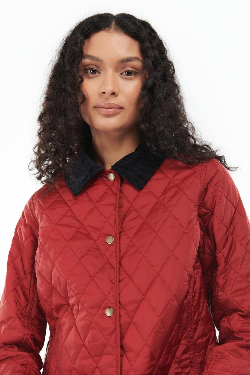Women's red quilted jacket close-up with black collar and gold button placket