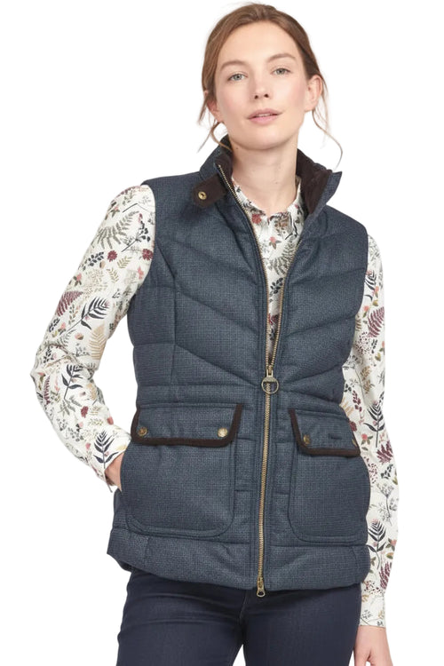 Women’s navy quilted gilet vest with stand collar, full zipper, and two front flap pockets.